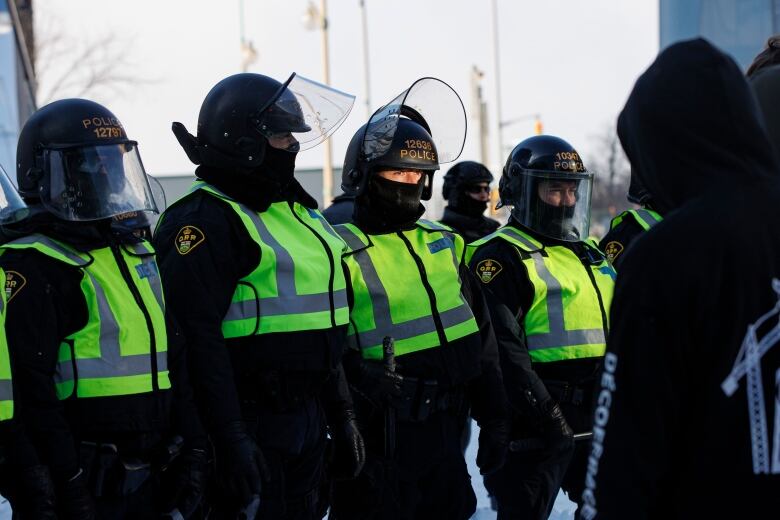 Police stand in a line outside.