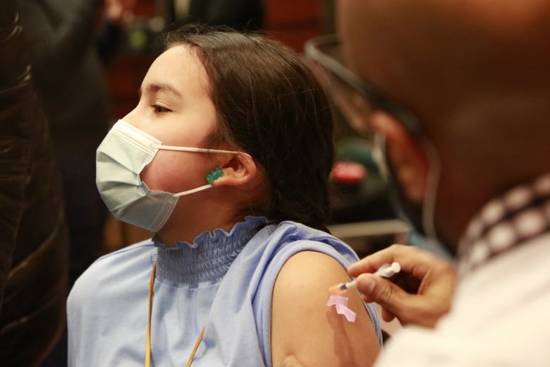 A child receives a Covid-19 vaccine in Winnipeg. A slow uptake by children under 12 in many provinces has health officials concerned about the immunization rate.