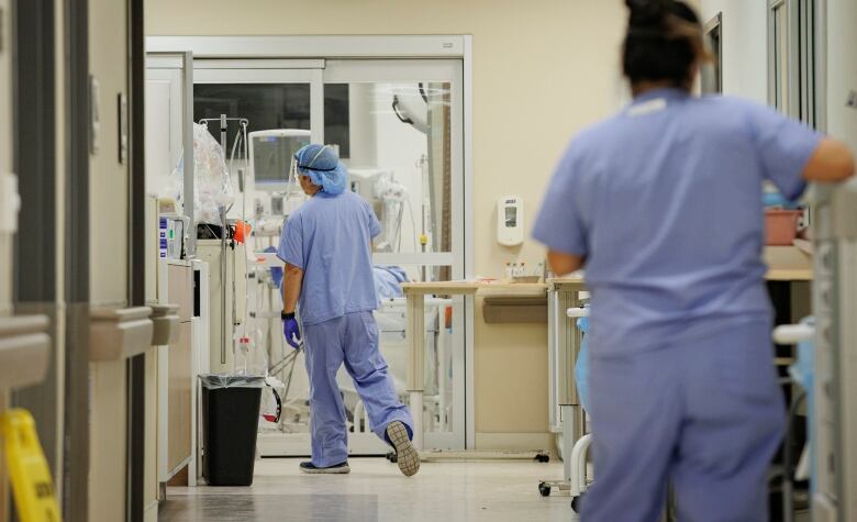 A hospital setting with two nurses in blue scrubs