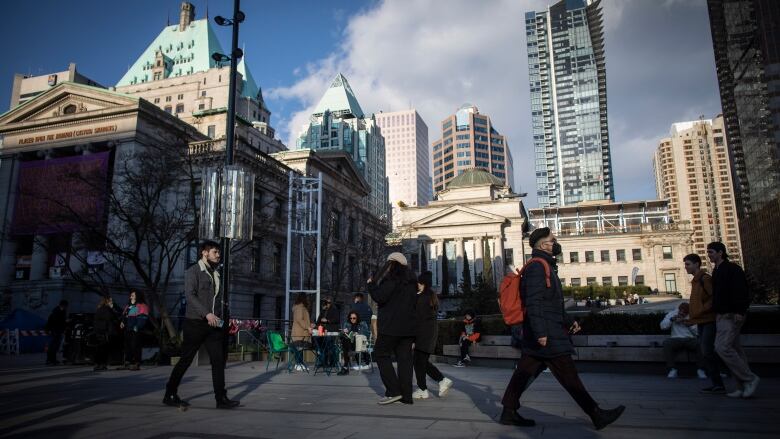 People walk through Robson Square near the Vancouver Art Gallery in Vancouver, British Columbia on Tuesday, March 8, 2022.