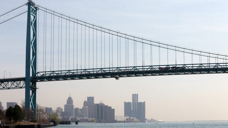 FILE- This April 29, 2015 file photo shows the Detroit skyline under the Ambassador Bridge. Most of the arguments made in a lawsuit by Ambassador Bridge owner Manuel Matty Moroun in his effort to stop the construction of a $2.1 billion competing government span were dismissed in federal court, Wednesday, Sept. 30, 2015. The remaining item involves an international crossing agreement between Michigan and Canada.  (AP Photo/Carlos Osorio, File)