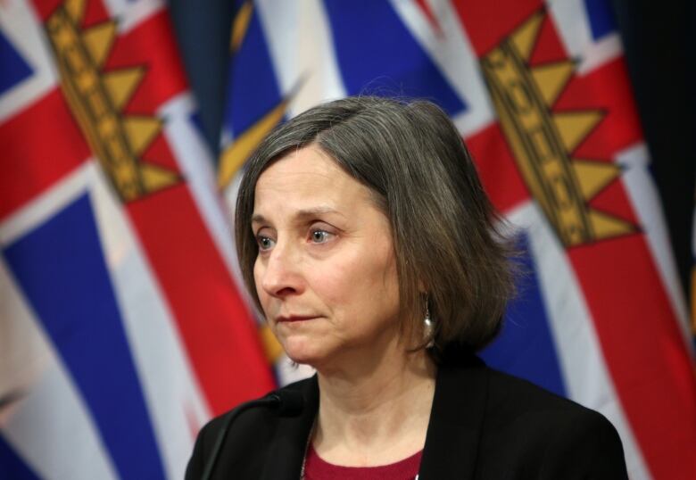 Chief coroner Lisa Lapointe stands at a rostrum with a grim look on her face.