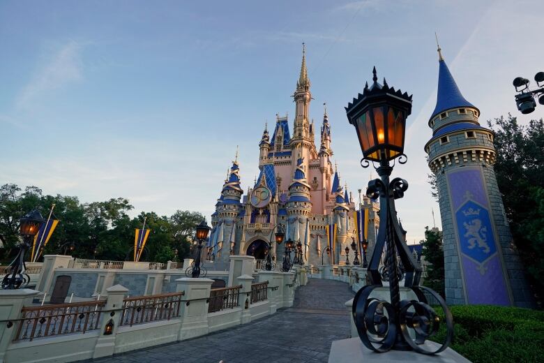 A blue, white and gold castle is shown behind a vintage streetlamp. 