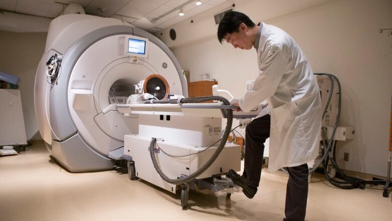 Doctor stands in front of MRI machine