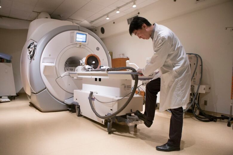 Doctor stands in front of MRI machine