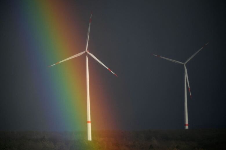 A rainbow is seen behind wind turbines near Breuna, western Germany on February 17, 2022.