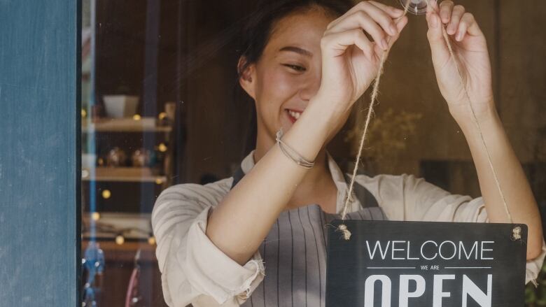 Woman holding Open sign.