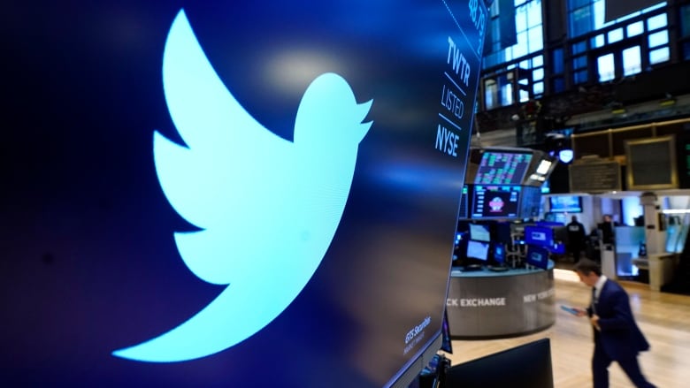 The Twitter logo is displayed on a large screen at a stock exchange. 