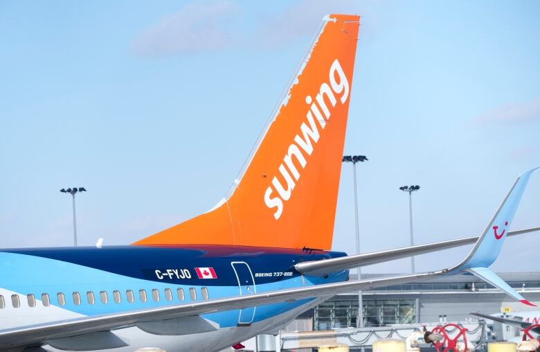 An airplane with an orange tail with the word 