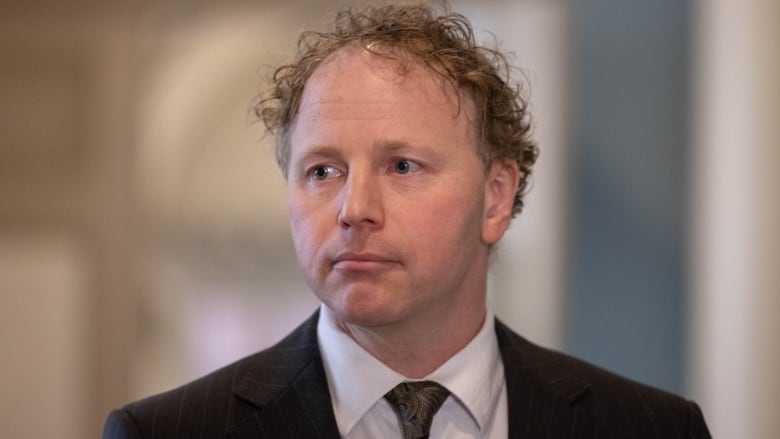 A headshot of a man wearing a suit.