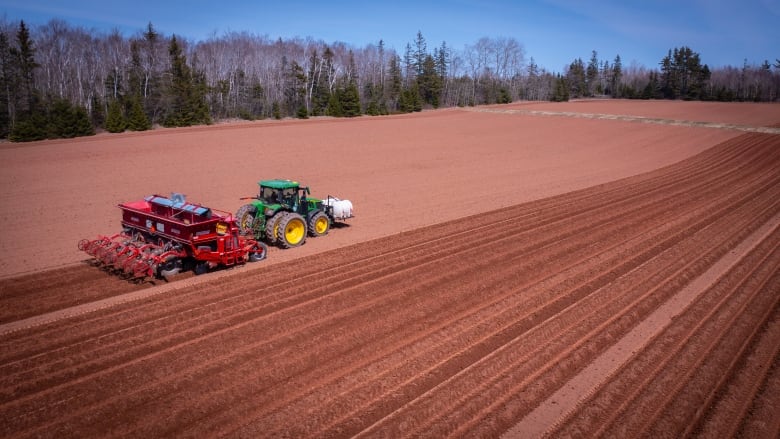 Aerial view of farm tractor at work in a field.