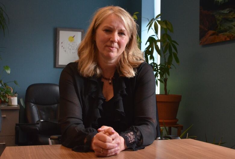 A woman sits at a desk.