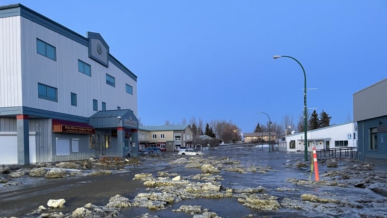 A street has water and ice sitting in it. 