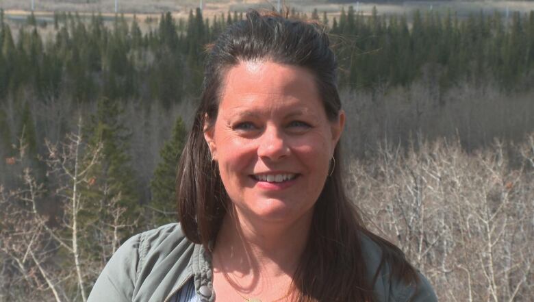 A woman smiles into the camera.