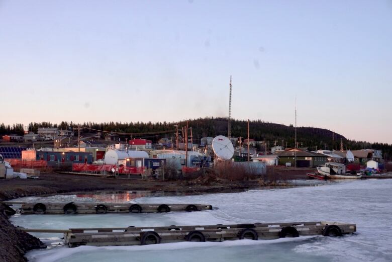 a waterfront image shows docks leading out onto the ice of a lake, with the town in the background