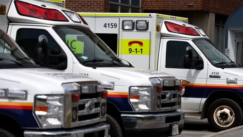 Three ambulances parked outside a hospital.