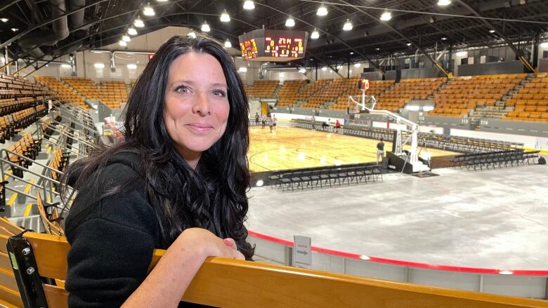 A person is sitting in a basketball arena. 