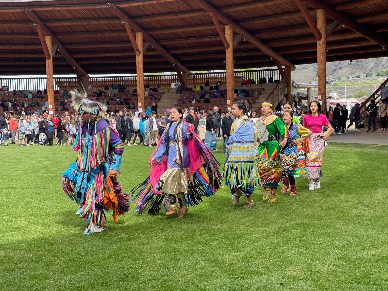 Powwow dancers perform at campground.