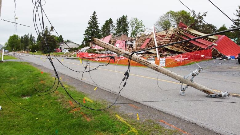 The debris from a building in an adjacent lumber yard in Clarence-Rockland lies fenced-off behind a broken hydro pole.