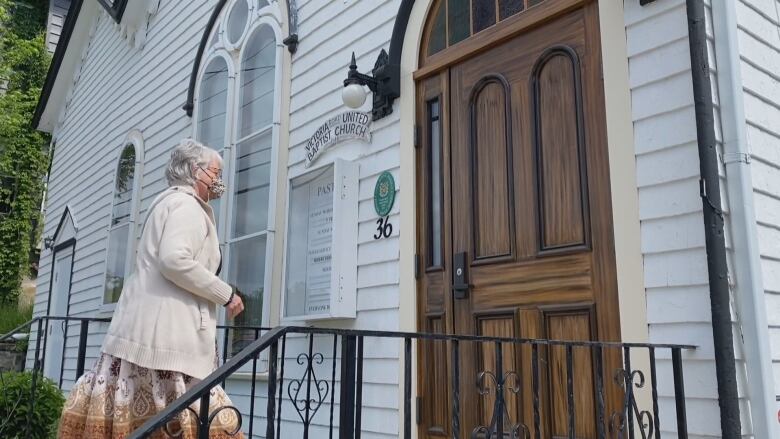 A white woman walking up some church stairs