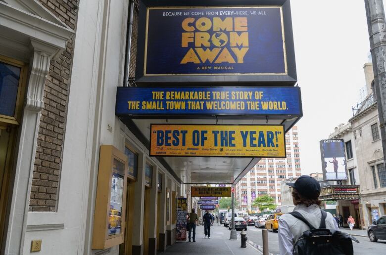 The marquee of the Broadway musical Come From Away above a New York sidewalk.