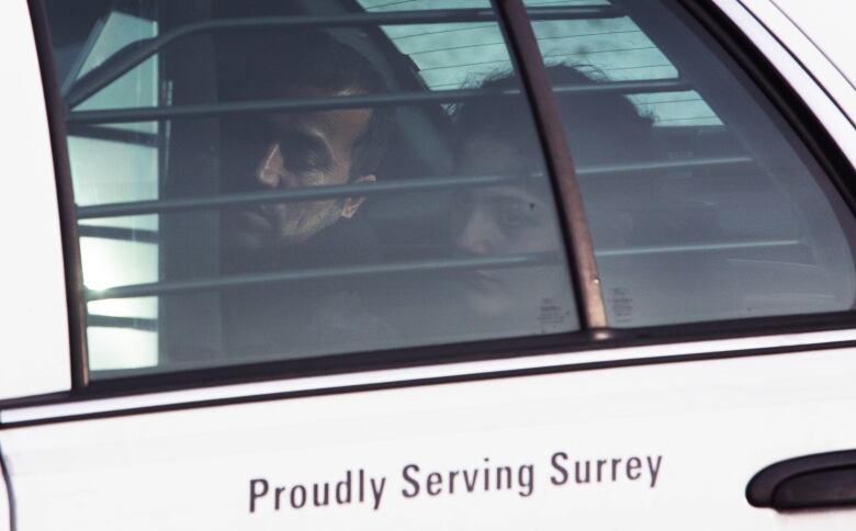 Ashki Shkur, then 12 years old, sits in the back of an RCMP cruiser with her father after she and her family walked across the border from the U.S. on Feb. 26, 2017.