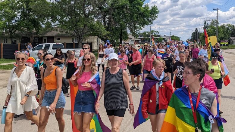 A group of people walk on the street during a pride parade. 