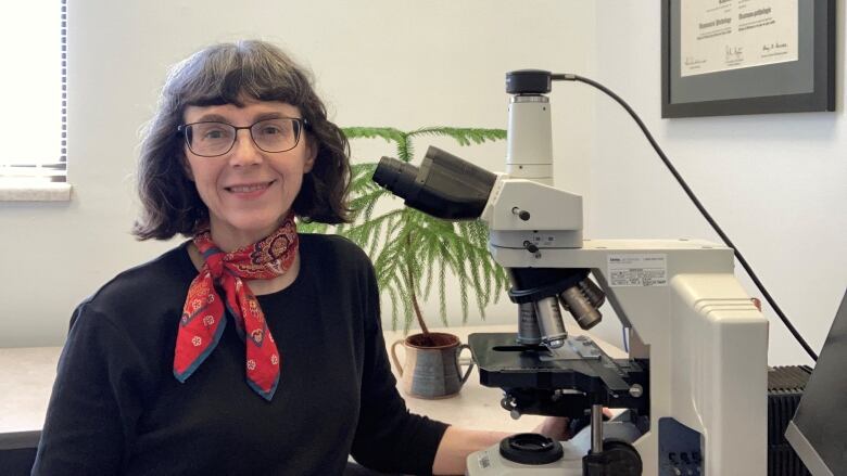 Pathologist Dr. Laurette Geldenhuys is pictured with a microscope.