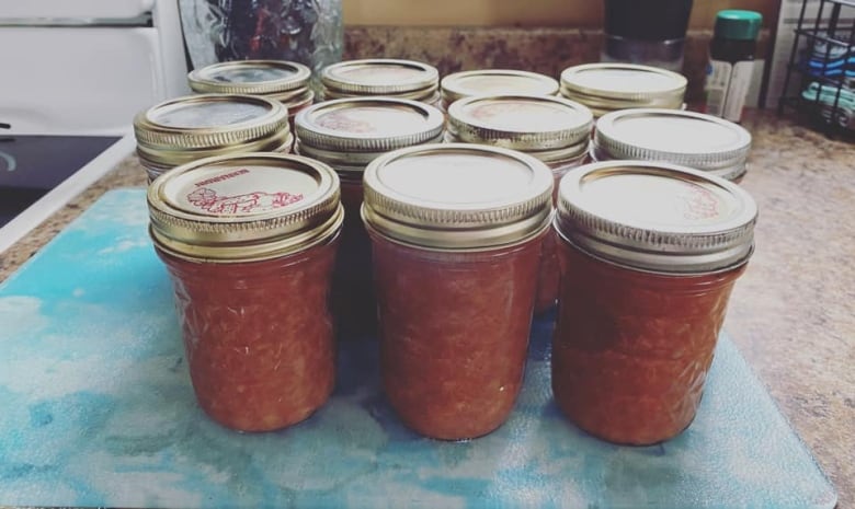 12 jars of rhubarb sauce on countertop.