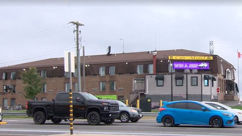 A photo from across the street of a large brown motel