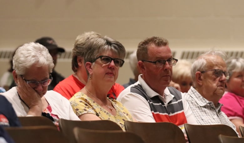 A row of people listening in an auditorium. 