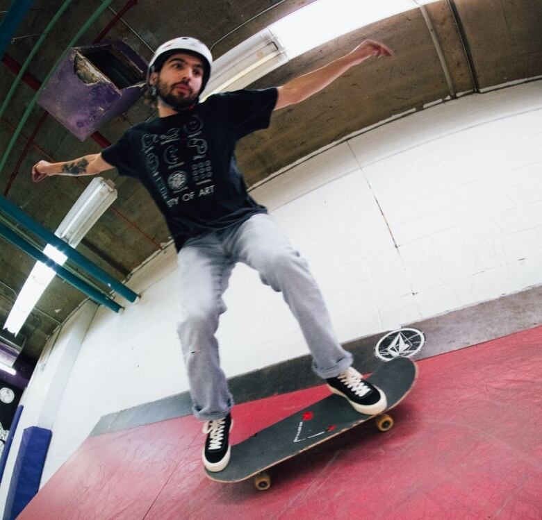 A person skateboards on a ramp.