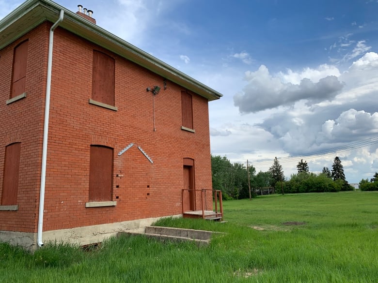 a brick building on green grass