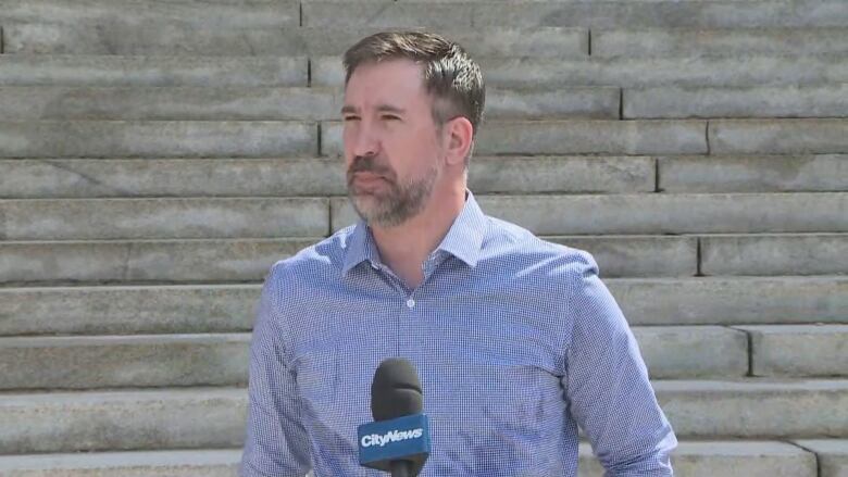 A headshot of Thomas Linner standing in front of concrete steps.