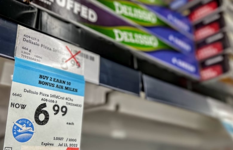 Frozen pizza is displayed with a price sticker offering bonus Air Miles in a Calgary Safeway store.