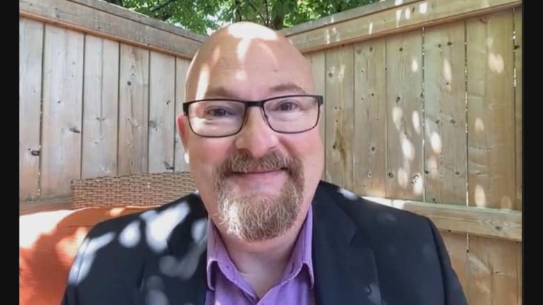 Man with glasses smiling at camera on a Zoom call.