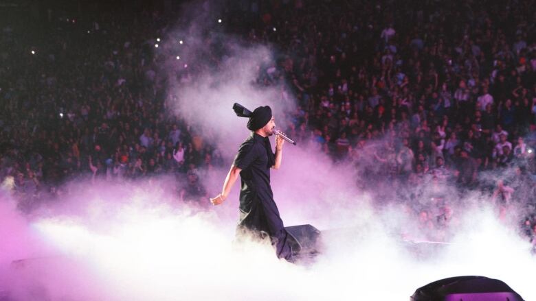 A man shrouded in smoke on stage.