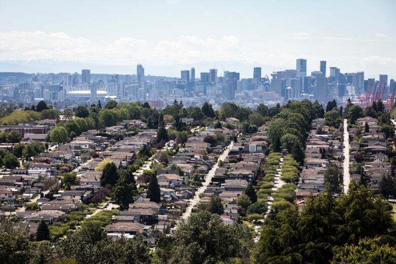 Rows of single-family homes are pictured in the foreground of the Vancouver skyline.