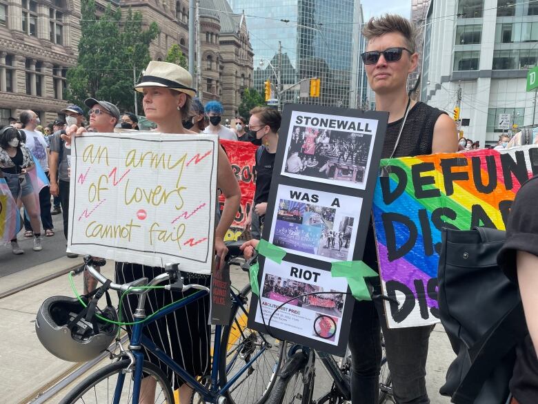 A downtown march with people holding colourful signs.