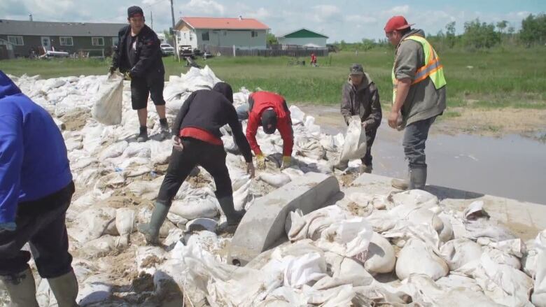 People walking on top of some sandbags