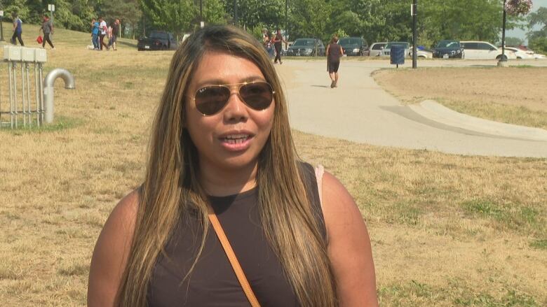 A woman stands in a park. 