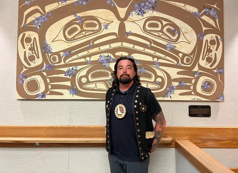 Peter Johnston stands in front of the First Nations art in the courtroom