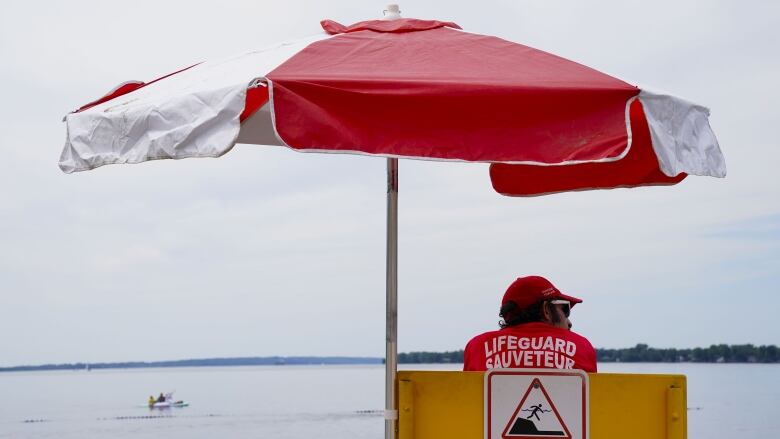 A lifeguard watches a beach at the edge of a river.