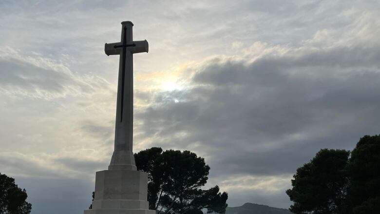 A cross monument overlooking a cemetery.