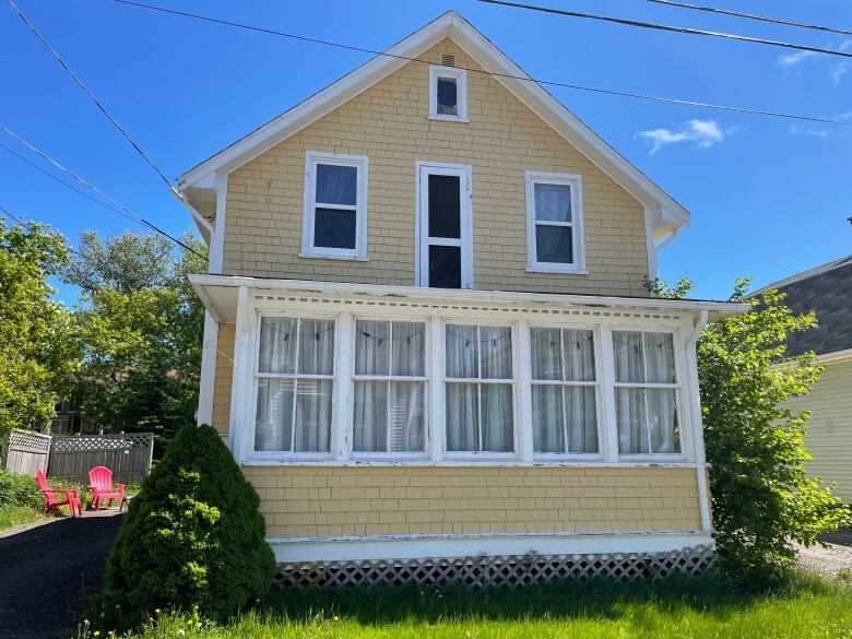 House with fading yellow paint and white trim.