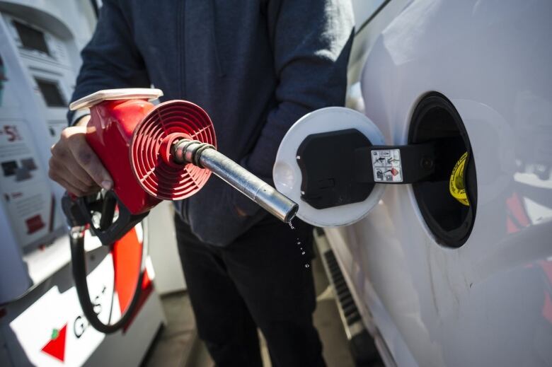 A gas pump pumps fuel into a car.