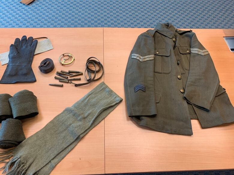 Military items and clothing presented on a table.