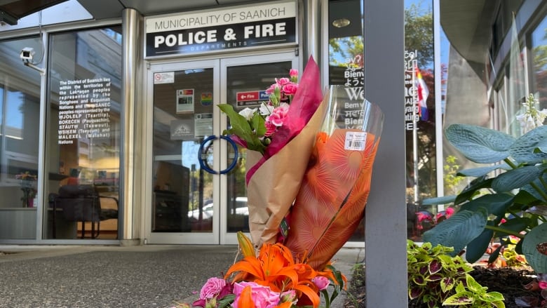 Flowers from members of the public are seen on Thursday, June 30, 2022 outside the entrance of Saanich Police Department, after six officers were wounded in a bank robbery two days earlier.