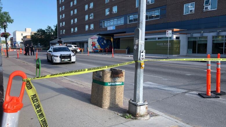 A street is blocked off with yellow police tape.