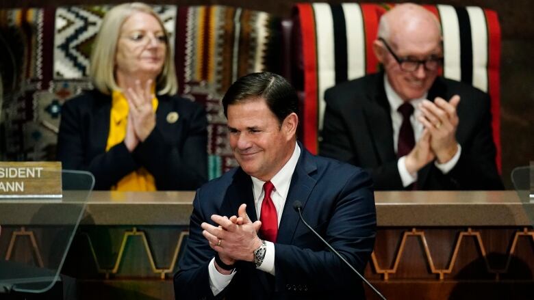 Gov. Doug Ducey applauds at the Arizona Capitol in this Jan. 10, 2022 file photo. Republicans in Arizona disagree about whether a pre-statehood law banning all abortions is now enforceable.